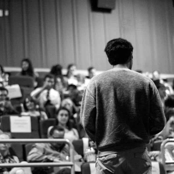 Arshum giving an introduction on A Day with God to the auditorium.